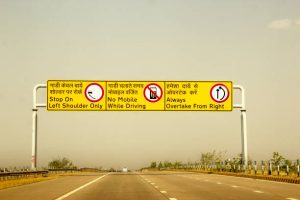 Bright yellow safety road sign on the Yamuna expressway leading to Agra and the Taj Mahal